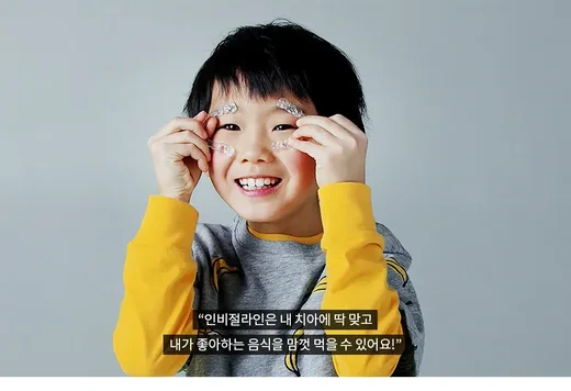 인비절라인 장치를 들고 웃는 어린이