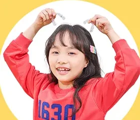 투명 교정장치를 들어 보이는 여자아이